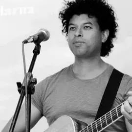 Black-and-white portrait of Martin Laps singing into a microphone while playing guitar